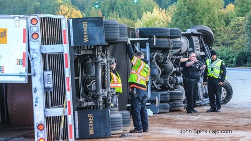 A tractor-trailer overturned on the ramp from I-285 West to Peachtree Industrial Boulevard Tuesday morning, blocking the ramp and causing some major delays through DeKalb County.