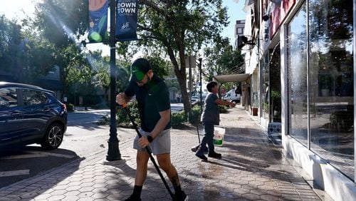 Amoz Costillo (front), owner of El Paso Tacos & Tequila, helped by Eluin Mianda, cleans up to be ready to reopen his restaurant in downtown Valdosta on Saturday. Hurricane Helene swept through Georgia, leading to at least 33 deaths. All 159 counties are now assessing the devastation and working to rebuild, even as serious flooding risks linger. (Hyosub Shin / AJC)