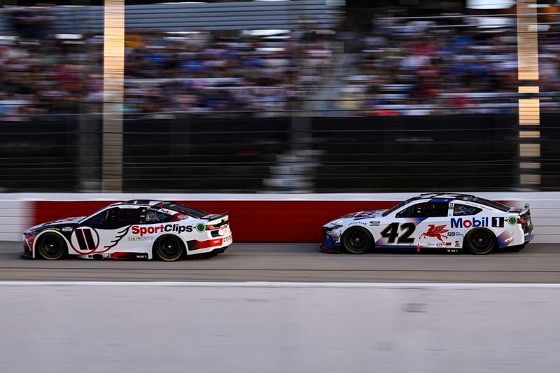 Denny Hamlin (11) and John Hunter Nemechek (42) compete down the front stretch during a NASCAR Cup Series auto race at Darlington Raceway, Sunday, Sept. 1, 2024, in Darlington, S.C. (AP Photo/Matt Kelley)