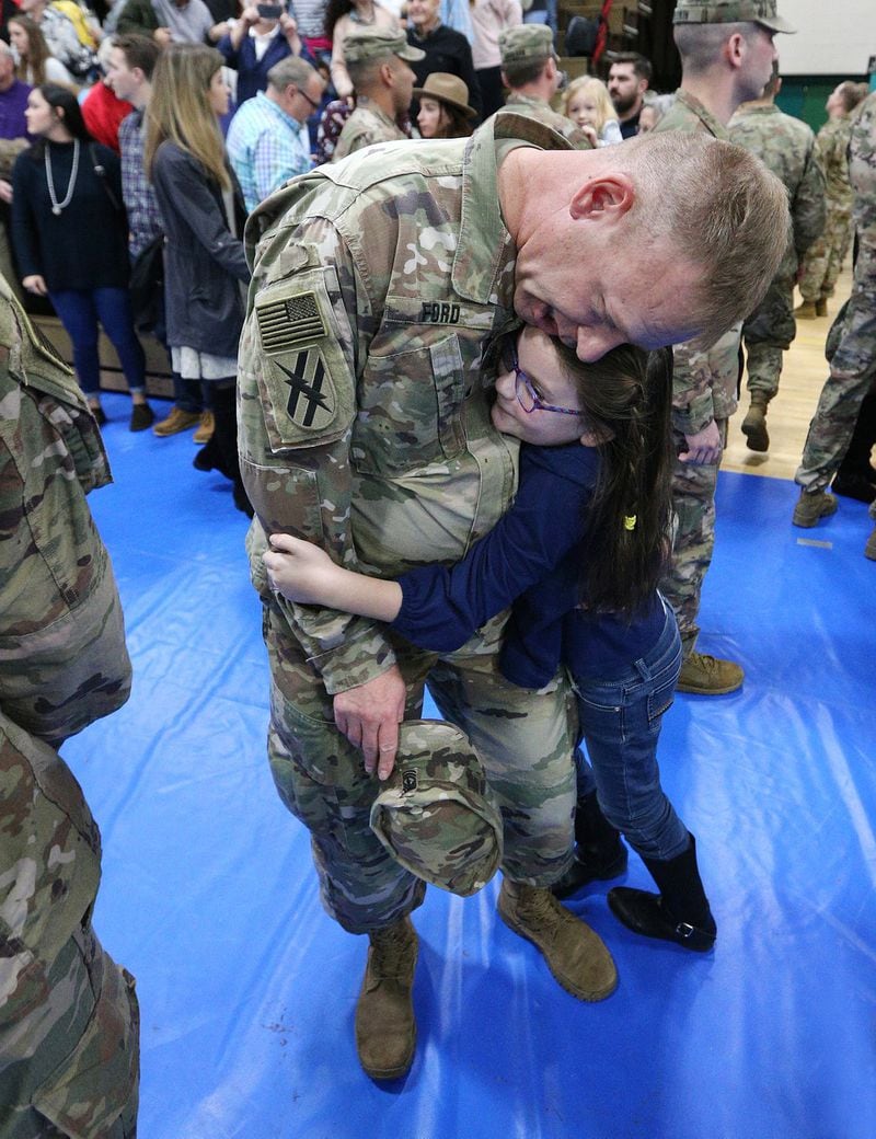 Seven-year-old Julianna hugs her father 1st Sgt. Archer Ford after the 48th Brigade’s departure ceremony at Fort Stewart. Curtis Compton/ccompton@ajc.com