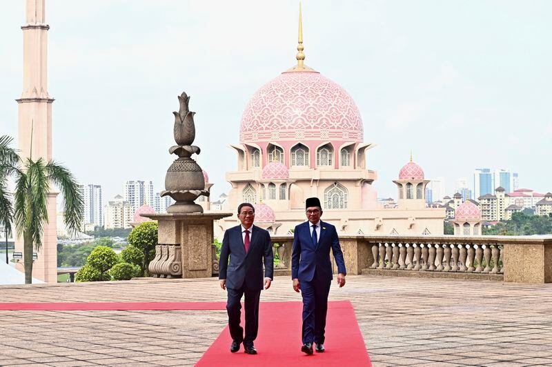 In this photo released by Malaysia's Department of Information, China's Premier Li Qiang, left, walks with Malaysia Prime Minister Anwar Ibrahim as he arrives at Putrajaya, Malaysia, Wednesday, June 19, 2024. (Malaysia's Department of Information via AP)