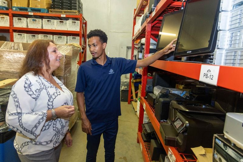 Samuale Ossire (right), owner of eCloud Recycle, shows Yvonne David some of the monitors his company has refurbished. PHIL SKINNER FOR THE ATLANTA JOURNAL-CONSTITUTION
