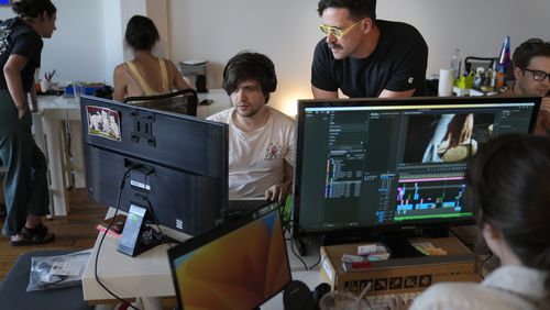 Chris Langer, top right, co-founder of CMYK, a digital design agency, speaks with an staff member at their office in New York, Tuesday, June 25, 2024. Last year, Langer started hearing chatter about the four-day work week, so he decided to try it out during the summer. (AP Photo/Seth Wenig)