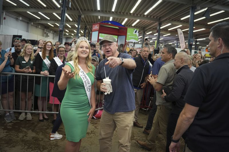 Democratic vice presidential candidate Minnesota Gov. Tim Walz visits the Minnesota State Fair and 2024 Princess Kay of the Milky Way Rachel Visser in the Dairy Building Sunday, Sept. 1, 2024 in Falcon Heights, Minn. (Glen Stubbe /Star Tribune via AP)