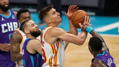 Atlanta Hawks guard Bogdan Bogdanovic (center) drives to the basket against Charlotte Hornets guard Terry Rozier (3) during the first quarter Sunday, April 11, 2021, in Charlotte, N.C. (Nell Redmond/AP)