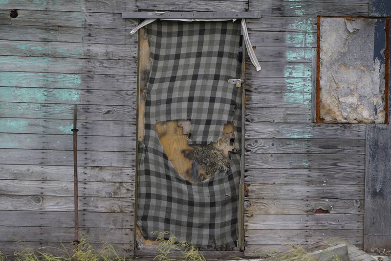 An abandoned home is locked up in Newtok, Alaska on Wednesday, Aug. 14, 2024. (AP Photo/Rick Bowmer)