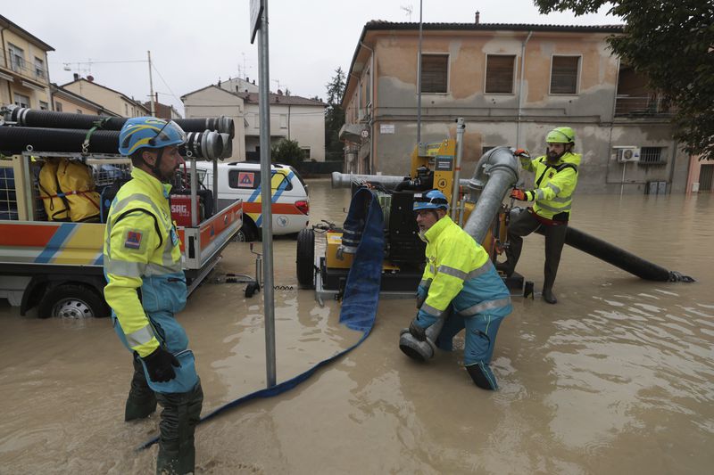 Workers try to pump away water after flooding in Faenza, in the region of Emilia Romagna, Italy, Thursday, Sept. 19, 2024. (Fabrizio Zani/LaPresse via AP)