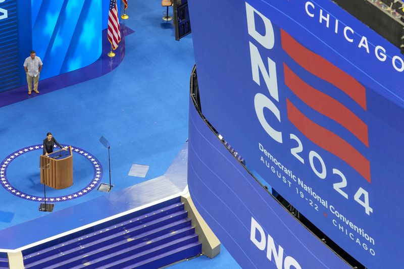 Rep. Alexandria Ocasio-Cortez, D-NY, stands at the podium at the Democratic National Convention at the United Center Saturday, Aug. 17, 2024, in Chicago. (AP Photo/Morry Gash)