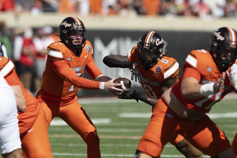 Oklahoma State quarterback Alan Bowman (7) hands the ball off to running back Ollie Gordon II (0) in the first half of an NCAA college football game against Utah Saturday, Sept. 21, 2024, in Stillwater, Okla. (AP Photo/Mitch Alcala)