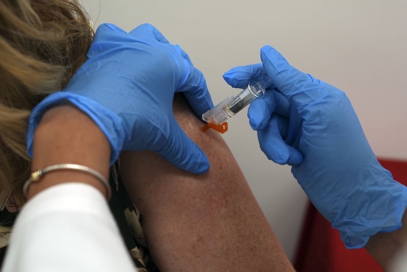 A pharmacist administers a COVID-19 vaccine at a pharmacy in New York, on Tuesday, Sept. 24, 2024. (AP Photo/Mary Conlon)