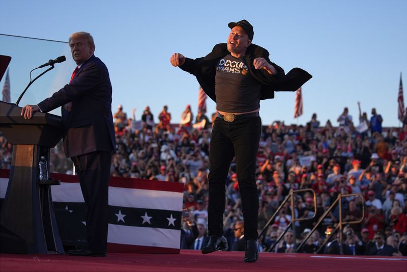 Elon Musk jumps on the stage as Republican presidential nominee former President Donald Trump speaks at a campaign rally at the Butler Farm Show, Saturday, Oct. 5, 2024, in Butler, Pa. (AP Photo/Evan Vucci)