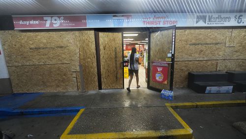 A customer enters a gas station that is boarded up in anticipation of Hurricane Francine, in Morgan City, La., Wednesday, Sept. 11, 2024. (AP Photo/Gerald Herbert)