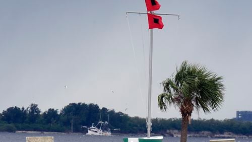 A shrimping boat makes her way back to port as hurricane flags fly at the Davis Islands Yacht Club, Monday, Oct. 7, 2024, in Tampa, Fla. (AP Photo/Chris O'Meara)