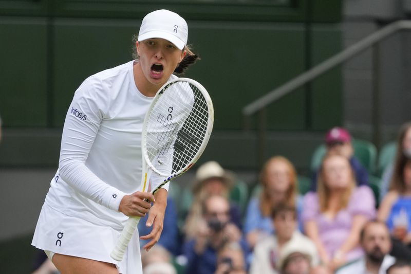 Iga Swiatek of Poland reacts after defeating Petra Martic of Croatia in their second round match at the Wimbledon tennis championships in London, Thursday, July 4, 2024. (AP Photo/Kirsty Wigglesworth)