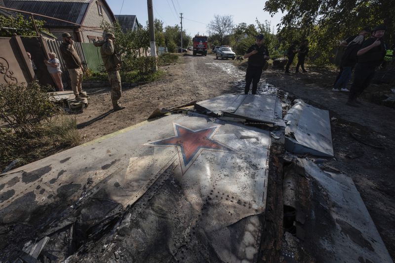 Ukrainian servicemen examine fragments of a Russian military plane that was shot down on the outskirts of Kostyantynivka, a near-front line city in the Donetsk region, Ukraine, Saturday, Oct. 5, 2024. (Iryna Rybakova via AP)