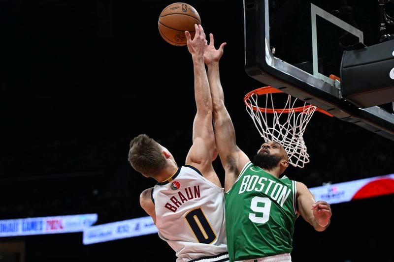 Boston Celtics Derrick White blocks Denver Nuggets Christian Braun during a preseason game between Boston Celtics and Denver Nuggets in Abu Dhabi, United Arab Emirates, Friday, Oct. 4, 2024. (AP Photo/Martin Dokoupil)