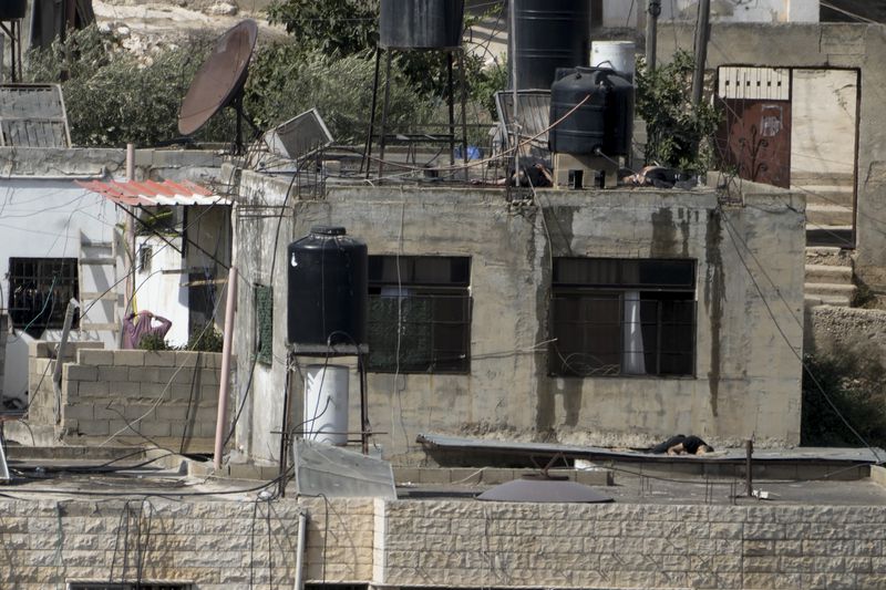 EDS NOTE: GRAPHIC CONTENT - Three bodies lie motionless on rooftops in the West Bank town of Qatabiya during a Israeli raid, Thursday, Sept. 19, 2024. (AP Photo/Majdi Mohammed)