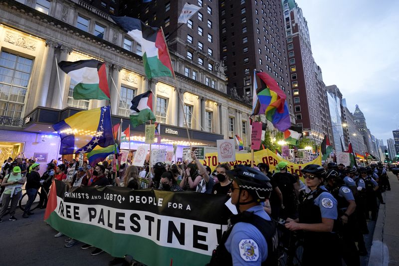 Protesters march passed a police line prior to the start of the Democratic National Convention Sunday, Aug. 18, 2024, in Chicago. (AP Photo/Frank Franklin II)