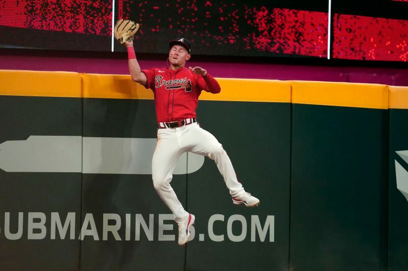 Atlanta Braves left fielder Jarred Kelenic makes a catch at the wall to retire Tampa Bay Rays' Jonny DeLuca in the ninth inning of a baseball game Friday, June 14, 2024, in Atlanta. (AP Photo/John Bazemore)