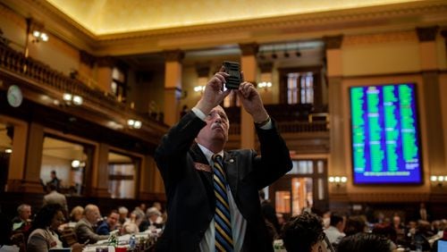 Rep. Tommy Benton takes a photo of voting results on Sine Die, the last day of the General Assembly at the Georgia State Capitol in Atlanta on Monday, April 4, 2022.   Branden Camp/ For The Atlanta Journal-Constitution