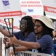 Dockworkers from Port Miami display signs at a picket line, Thursday, Oct. 3, 2024, in Miami. (AP Photo/Marta Lavandier)