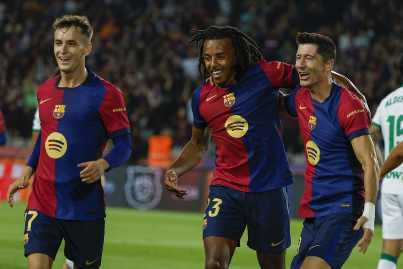 Barcelona's Robert Lewandowski, right, celebrates with teammates after scoring the opening goal during a Spanish La Liga soccer match between Barcelona and Getafe at the Olympic stadium in Barcelona, Spain, Wednesday, Sept. 25, 2024. (AP Photo/Joan Monfort)