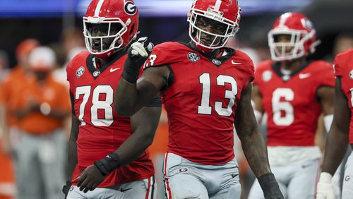 Georgia's star defensive end Mykel Williams (13), shown here with teammate Nazir Stackhouse (78) early in the season opener against Clemson, is listed as 'doubtful' on the SEC's Availability Report for the No. 1-ranked Bulldogs' game against Kentucky in Lexington on Saturday. Williams suffered an ankle injury against Clemson and did not play last Saturday against Tennessee Tech. (Jason Getz / AJC)