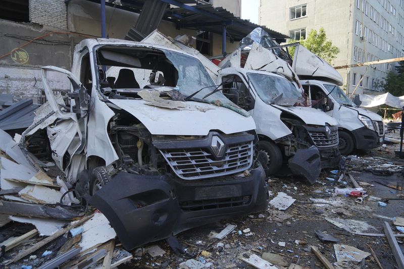 A view of Nova Poshta delivery vehicles damaged after a Russian attack in Kharkiv, Ukraine, Sunday, June 30, 2024. One person was killed and several were injured. (AP Photo/Andrii Marienko)
