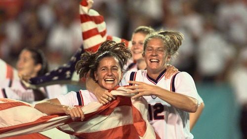 Joy Fawcett (left) and Carin Gabarra (right) run around Sanford Stadium in Athens with an American flag after their historic 2-1 gold medal win over China Thursday, Aug. 1, 1996, during the 1996 Summer Olympic Games. (David Tulis/AJC)