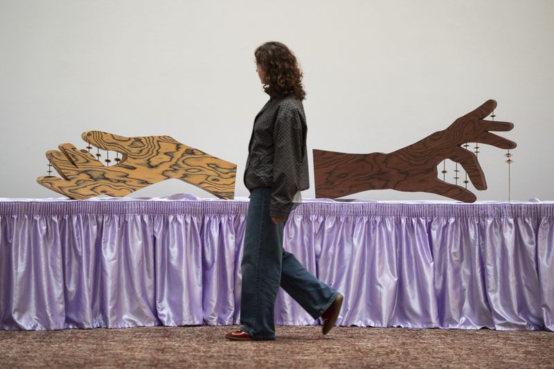 A woman walks past an artwork by Jasleen Kaur during the Turner Prize 2024 press preview at Tate Britain in London, part of the 40th anniversary exhibition featuring four shortlisted artists, Tuesday, Sept. 24, 2024. (AP Photo/Thomas Krych)