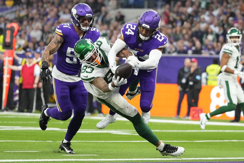 Minnesota Vikings' Camryn Bynum (24), right, fights for the ball with New York Jets' Tyler Conklin (83), center, during the second half of an NFL football game, Sunday, Oct. 6, 2024, at the Tottenham Hotspur stadium in London. (AP Photo/Kirsty Wigglesworth)