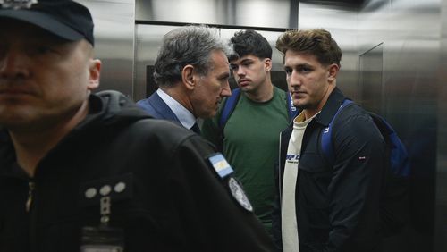 French rugby players Oscar Jegou, right, and Hugo Auradou, second from right, stand next to their lawyer Rafael Cuneo Libarona at the airport in Buenos Aires, Argentina, Tuesday, Sept. 3, 2024. Argentine prosecutors decided to let Auradou and Jegou leave the country despite the players remaining under investigation for alleged rape. (AP Photo/Gustavo Garello)