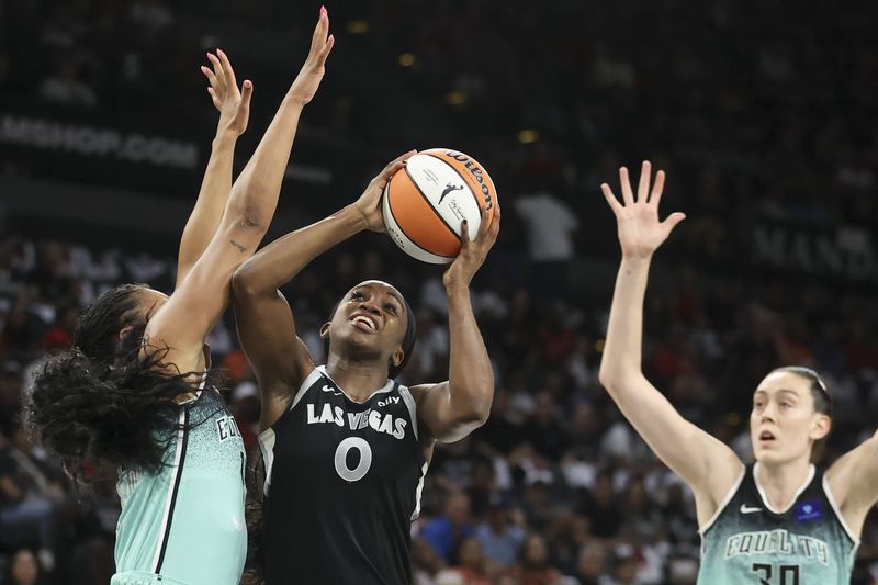 Las Vegas Aces guard Jackie Young (0) shoots over New York Liberty forward Betnijah Laney-Hamilton (44) during the first half of a WNBA Semifinal game Sunday, Oct. 6, 2024, in Las Vegas. (AP Photo/Ian Maule)