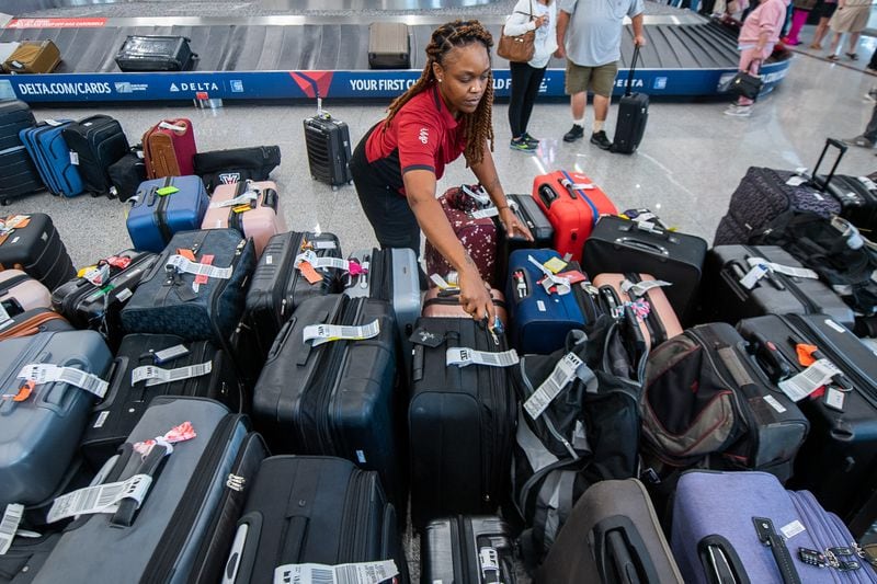 A ramp worker scans the luggage in the south terminal in Hartsfield-Jackson Atlanta International Airport in Atlanta on Sunday, July 21, 2024.  (Ziyu Julian Zhu / AJC)