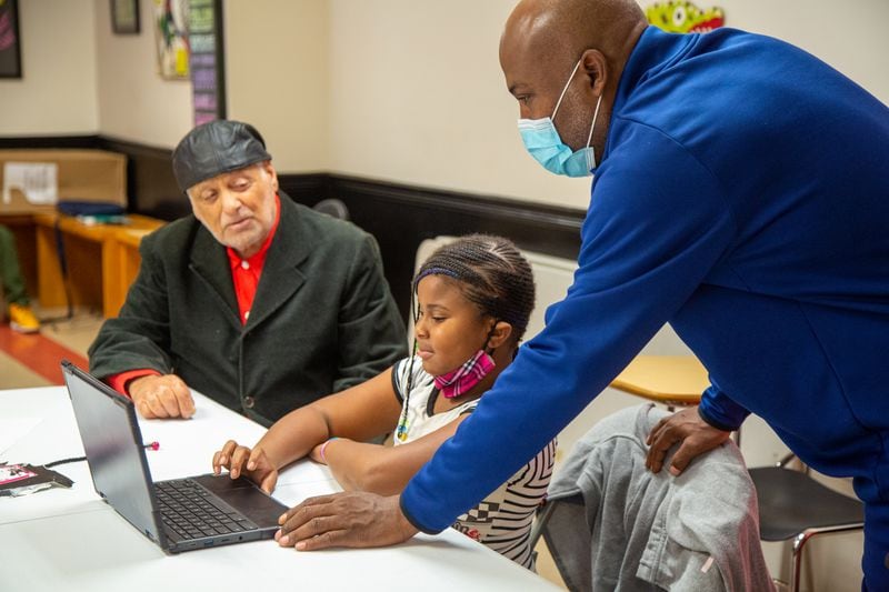 (left to right) Rick McDevitt watches as eight-year-old Maddison Brown gets help doing her homework from program & facilities manager, George Epps at The Rick McDevitt Youth Center. PHIL SKINNER FOR THE ATLANTA JOURNAL-CONSTITUTION.