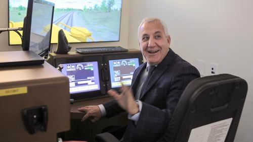 FILE - Union Pacific CEO Jim Vena tries his hand at one of the railroad's locomotive simulators that are used to train engineers at the company's headquarters in Omaha, Neb., Dec. 15, 2023. Union Pacific has reported steady growth ever since Vena took over the company in 2023. (AP Photo/Josh Funk, File)