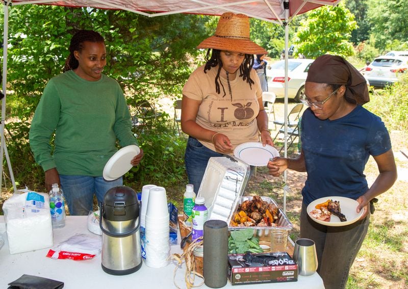 Keisha Cameron (from left) Alsie Parks and Whitney Jaye get some lunch during a break from helping Musa and Micole Hasan with their farm in Monroe. Phil Skinner for The Atlanta Journal-Constitution 