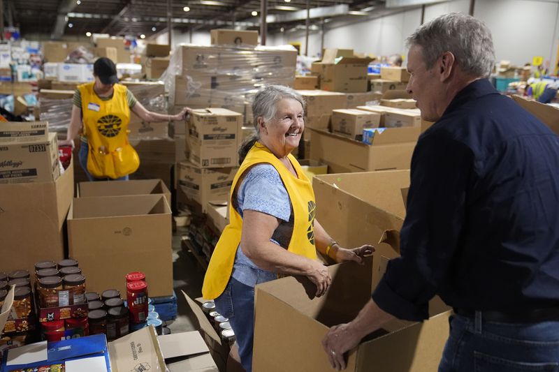 Volunteer Ann Davis speaks with Gov. Bill Lee, right, during his visit to the East Tennessee Disaster Relief Center, for Hurricane Helene disaster response Monday, Oct. 7, 2024, in Bristol, Tenn. (AP Photo/George Walker IV via Pool)