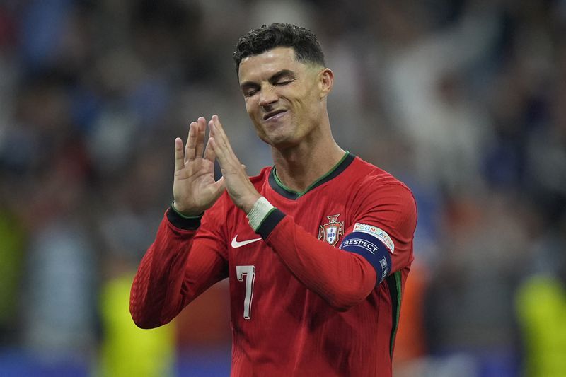 Portugal's Cristiano Ronaldo reacts after scoring in penalty shoot outs of a round of sixteen match between Portugal and Slovenia at the Euro 2024 soccer tournament in Frankfurt, Germany, Monday, July 1, 2024. (AP Photo/Matthias Schrader)