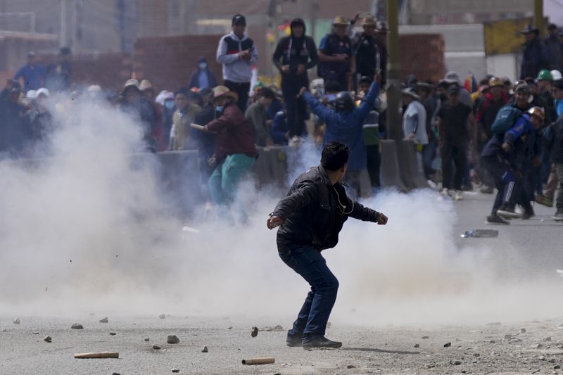 A supporter of former President Evo Morales clashes with supporters of current President Luis Arce during a march to La Paz, in El Alto, Bolivia, Sunday, Sept. 22, 2024. (AP Photo/Juan Karita)