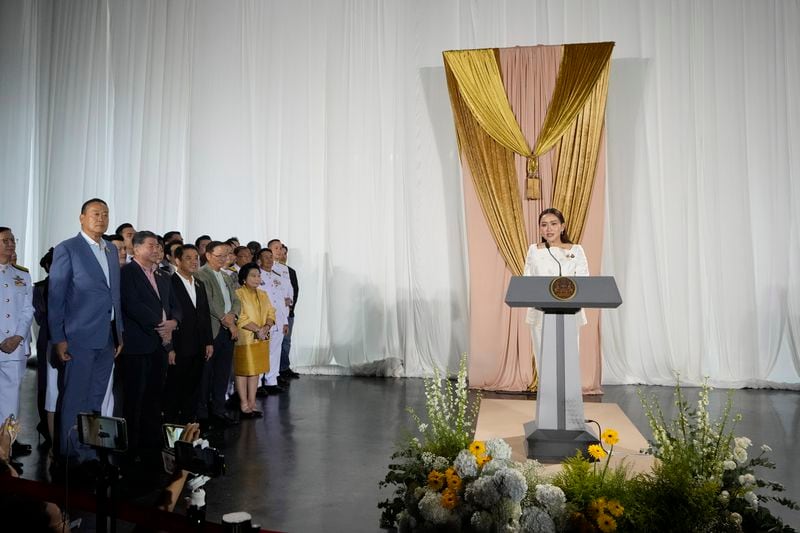 Thailand's new Prime Minister Paetongtarn Shinawatra, rihgt, talks to media after receiving a royal letter of endorsement for the post at the Pheu Thai party headquarters in Bangkok, Thailand Sunday, Aug. 18, 2024. (AP Photo/Sakchai Lalit)