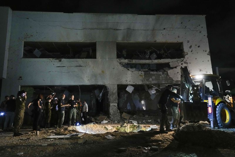 Israeli military and police work at a damaged school building that was hit by missiles fired from Iran in Gadera, Israel, Tuesday, Oct. 1, 2024. (AP Photo/Tsafrir Abayov)