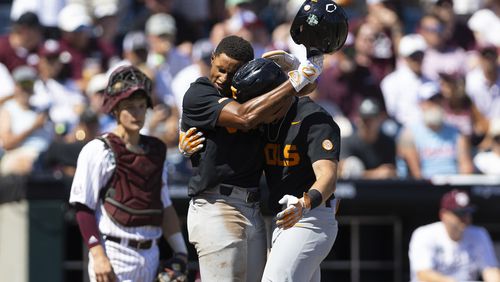 Tennessee's Christian Moore, left, hugs Dylan Dreiling at home plate after Dreiling hit a two-run home run against Texas A&M in the seventh inning of Game 2 of the NCAA College World Series baseball finals in Omaha, Neb., Sunday, June 23, 2024. (AP Photo/Rebecca S. Gratz)