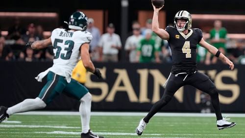 New Orleans Saints quarterback Derek Carr (4) fakes a pass as she scrambles against Philadelphia Eagles linebacker Zack Baun (53) in the second half of an NFL football game in New Orleans, Sunday, Sept. 22, 2024. (AP Photo/Gerald Herbert)