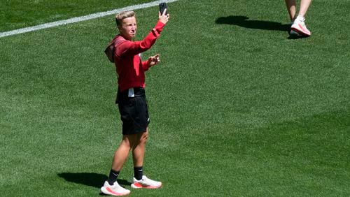 Coach Beverly Priestman of Canada takes photos on the pitch at Geoffroy-Guichard Stadium ahead of the 2024 Summer Olympics, Tuesday, July 23, 2024, in Saint-Etienne, France. Canada is scheduled to play New Zealand on Thursday, July 25. (AP Photo/Silvia Izquierdo)