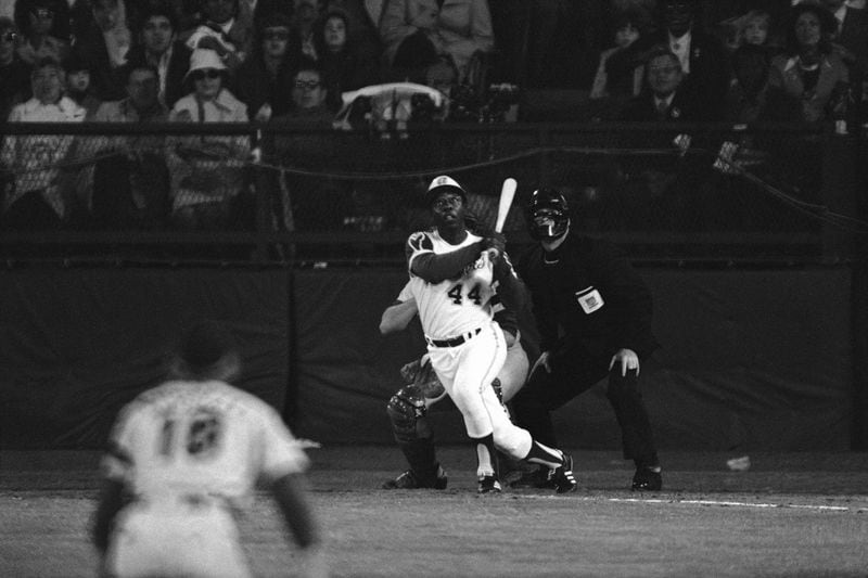 Atlanta Braves' Hank Aaron eyes the flight of the ball after hitting his 715th career homer in a game against the Los Angeles Dodgers in Atlanta, Ga., Monday night, April 8, 1974. Aaron broke Babe Ruth's record of 714 career home runs. Dodgers southpaw pitcher Al Downing, catcher Joe Ferguson and umpire David Davidson look on. (AP Photo/Harry Harris)