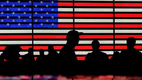 FILE - People gather near an electronic display of an American flag in Times Square in New York on Aug. 9, 2024. (AP Photo/Pamela Smith, File)