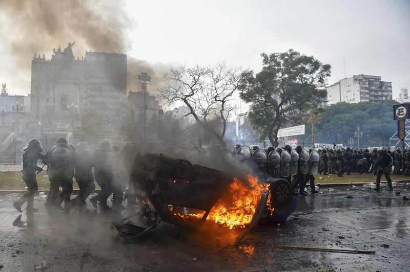 A car burns as police clear the streets of anti-government protesters outside Congress, where lawmakers debate a reform bill promoted by Argentine President Javier Milei in Buenos Aires, Argentina, Wednesday, June 12, 2024. (AP Photo/Gustavo Garello)