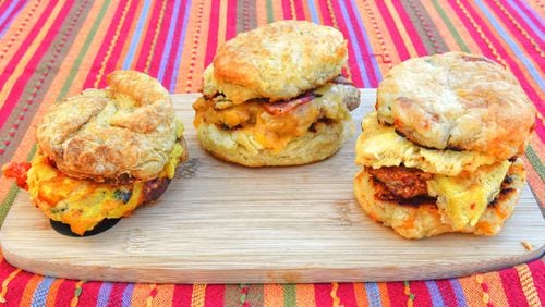 Vegan Florentine Biscuit (from left), Kentucky Hot Brown Biscuit and the Atomic Biscuit at Bomb Biscuits. (Chris Hunt for The Atlanta Journal-Constitution)