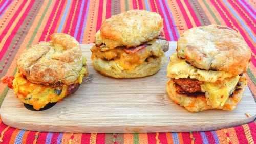 Among the offerings at Bomb Biscuits are (from left) a vegan Florentine biscuit, a Kentucky hot brown biscuit and the Atomic biscuit. Chris Hunt for The Atlanta Journal-Constitution